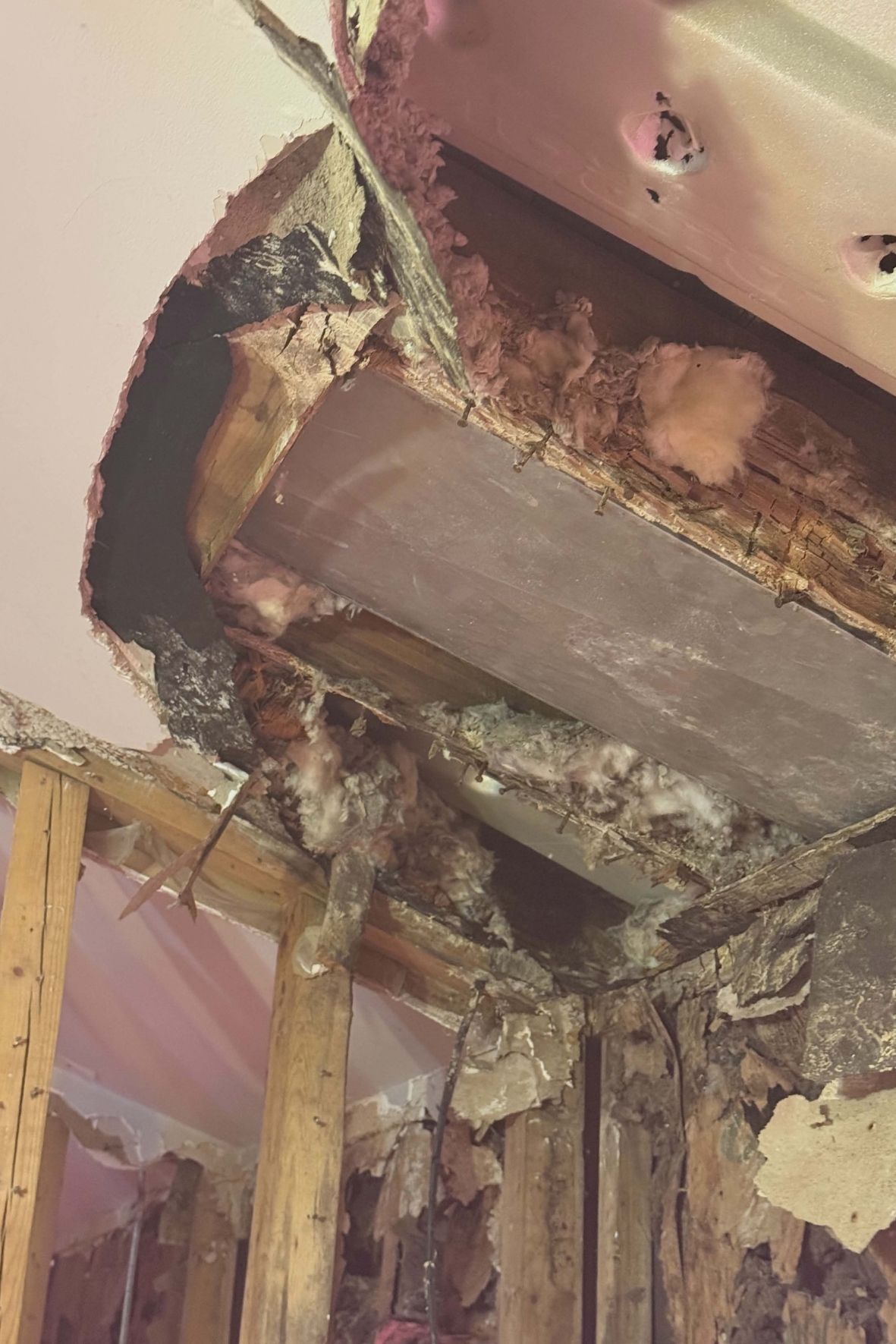 Charpente murale et plafond partiellement ouverts avec isolant apparent dans une maison à Laval